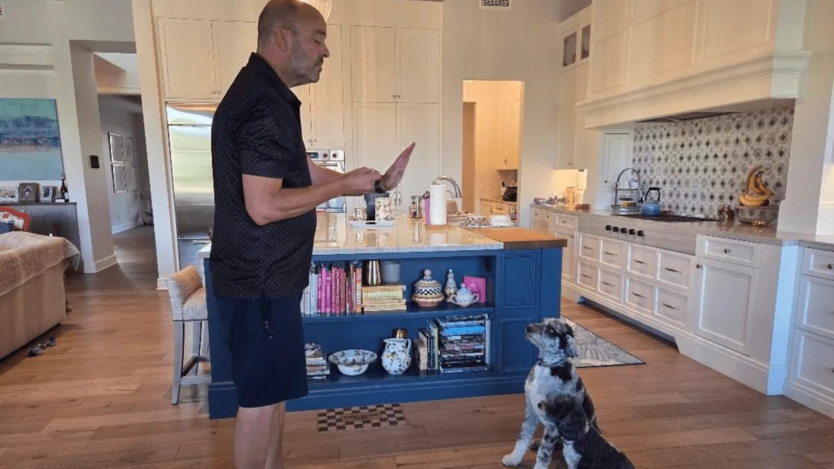 Mark Siebel using a hand signal with a dog during in-home dog training